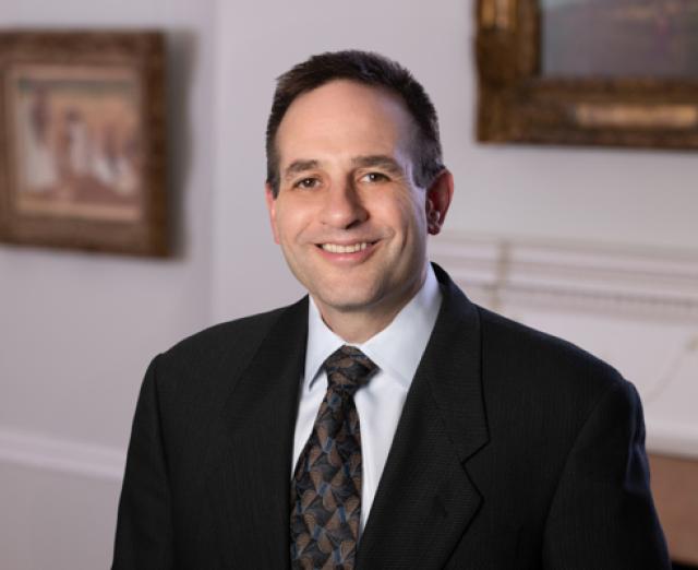 Man wearing a suit and tie smiling